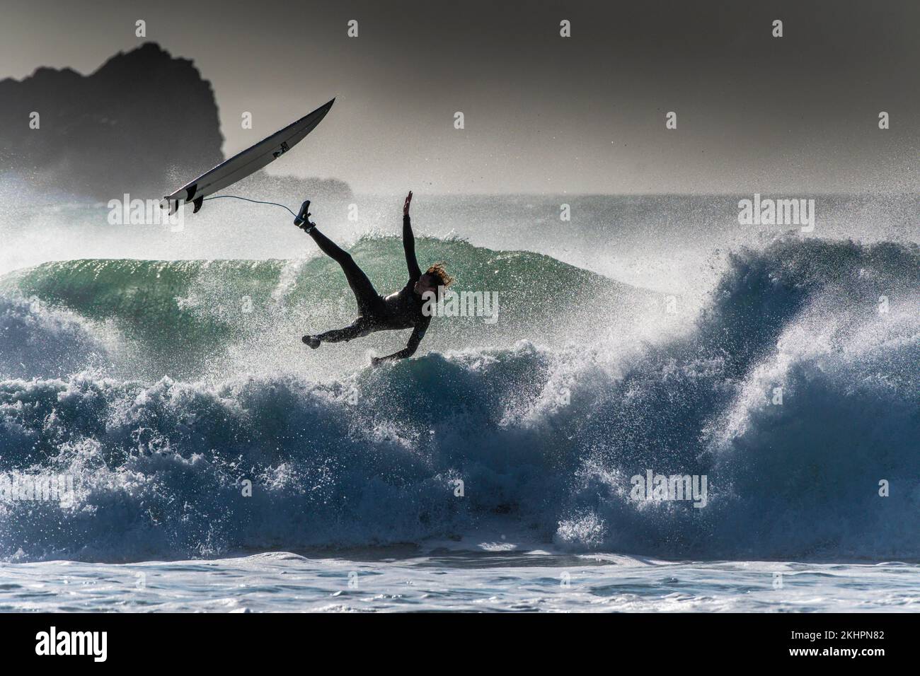 Un surfista che perde equilibrio e si sta spazzando via a Fistral a Newquay in Cornovaglia nel Regno Unito. Foto Stock