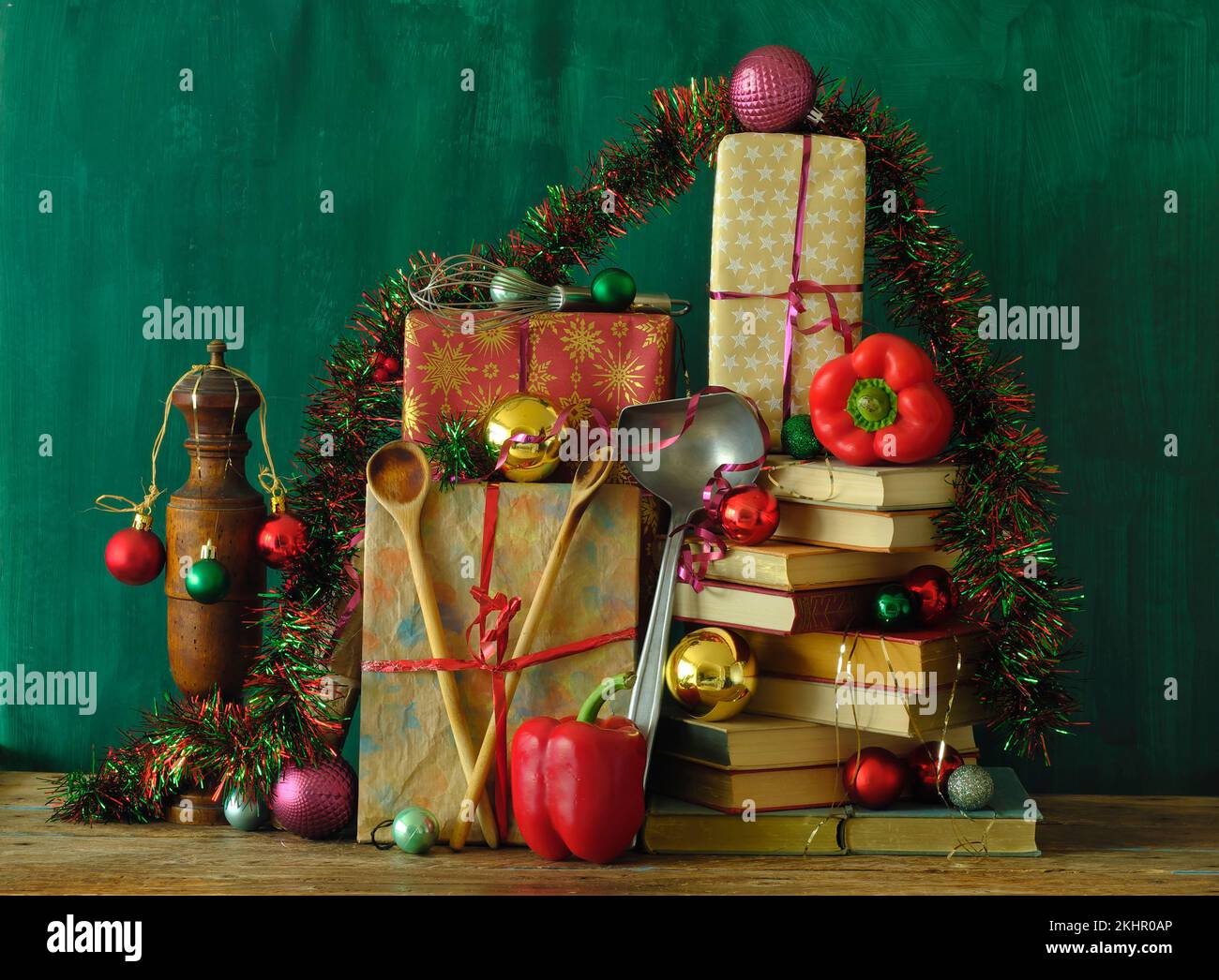 Libri di cucina come regalo di natale, cucina, culinaria, cibo, lettura, letteratura, natale, vacanza concept.festive decorazione con peperone e utensili da cucina Foto Stock