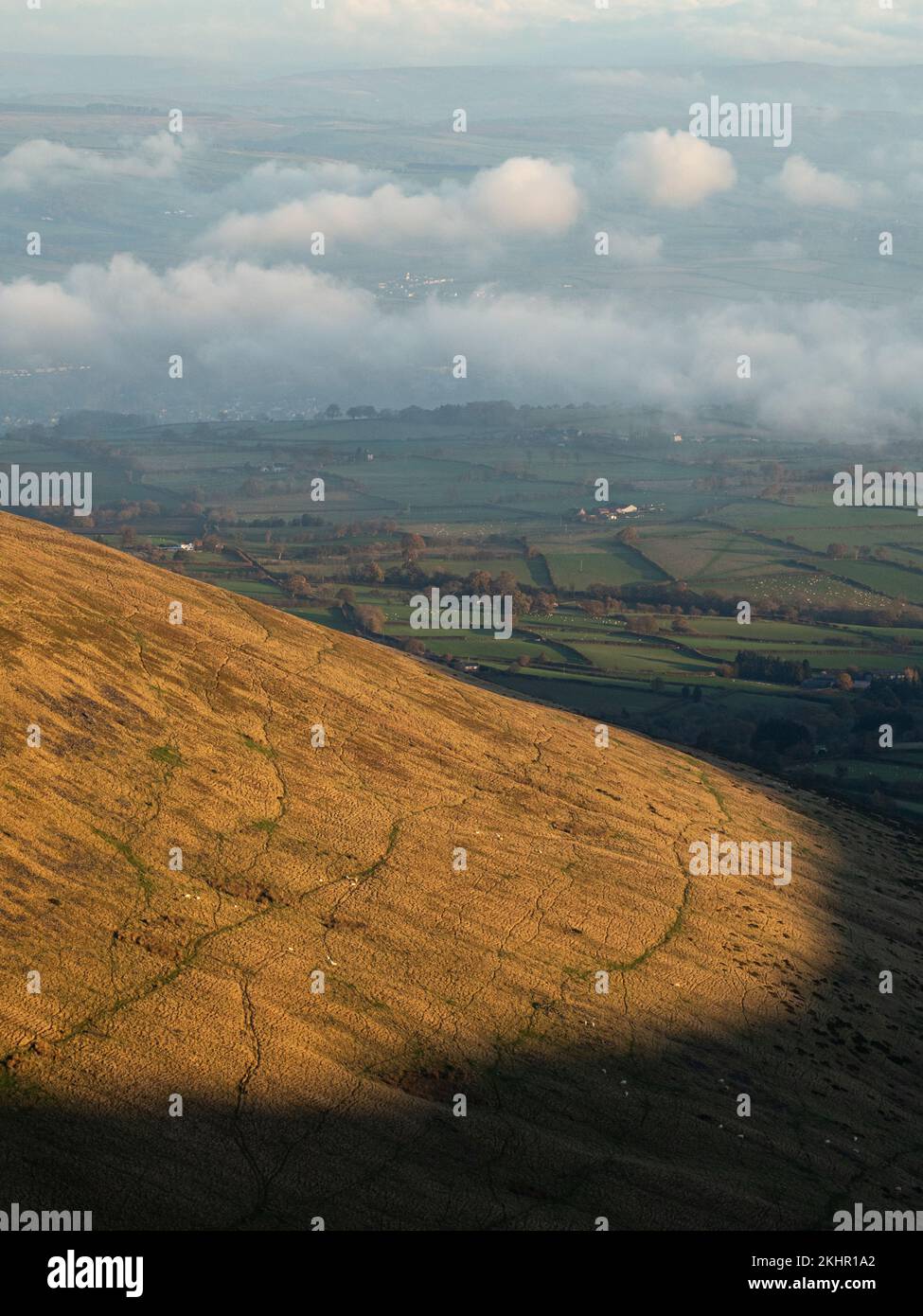 Una calda luce all'alba colpisce le colline di Brecon Beacon, guardando verso il basso nella valle Foto Stock