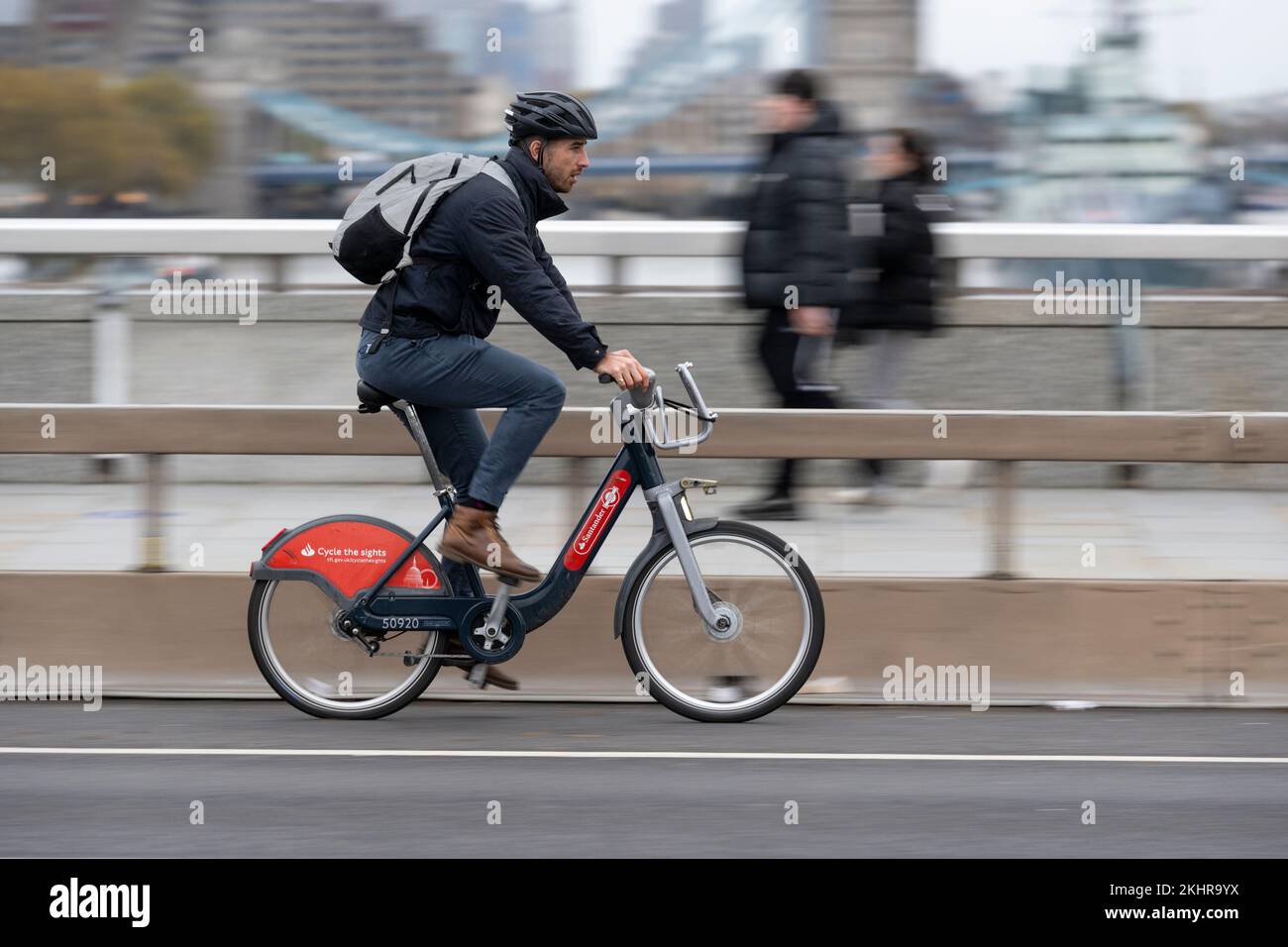Un uomo che pedala durante l'ora di punta, attraverso il London Bridge, su una bicicletta a noleggio Transport for London Santander Cycles, comunemente nota come "Boris Bike". Lo Foto Stock