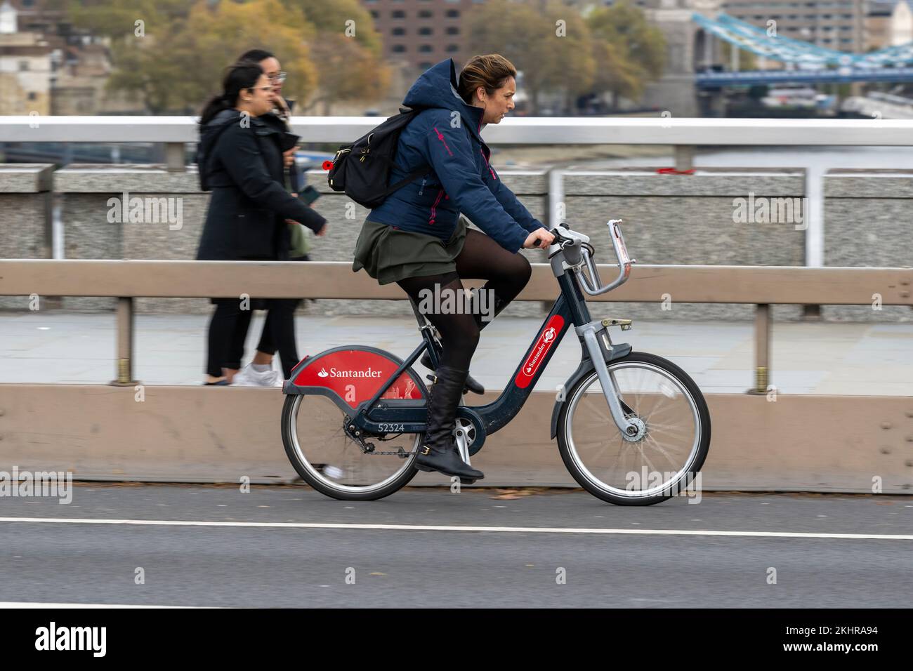 Una donna che pedala durante l'ora di punta, attraverso il London Bridge, su una bicicletta a noleggio Transport for London Santander Cycles, comunemente nota come "Boris Bike". Foto Stock