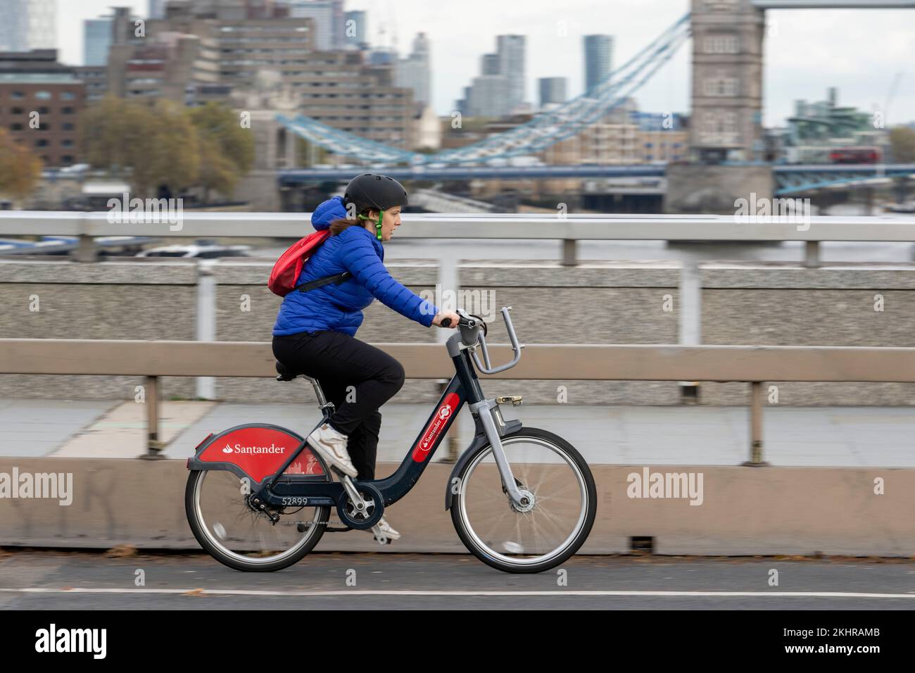 Una donna che pedala durante l'ora di punta, attraverso il London Bridge, su una bicicletta a noleggio Transport for London Santander Cycles, comunemente nota come "Boris Bike". Foto Stock