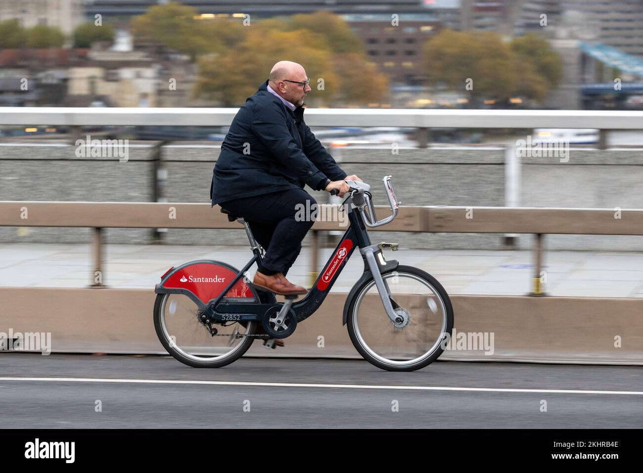 Un uomo che pedala durante l'ora di punta, attraverso il London Bridge, su una bicicletta a noleggio Transport for London Santander Cycles, comunemente nota come "Boris Bike". Lo Foto Stock