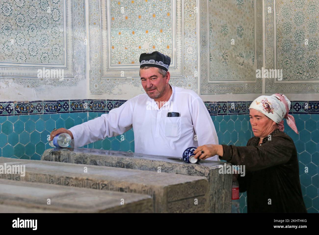 Imam benedice l'acqua per curare un bambino malato, Mausoleo di Gumbazi Saidon, complesso di AK Saray, Shakhrisabz, Provincia di Qashqadaryo, Uzbekistan, Asia centrale Foto Stock
