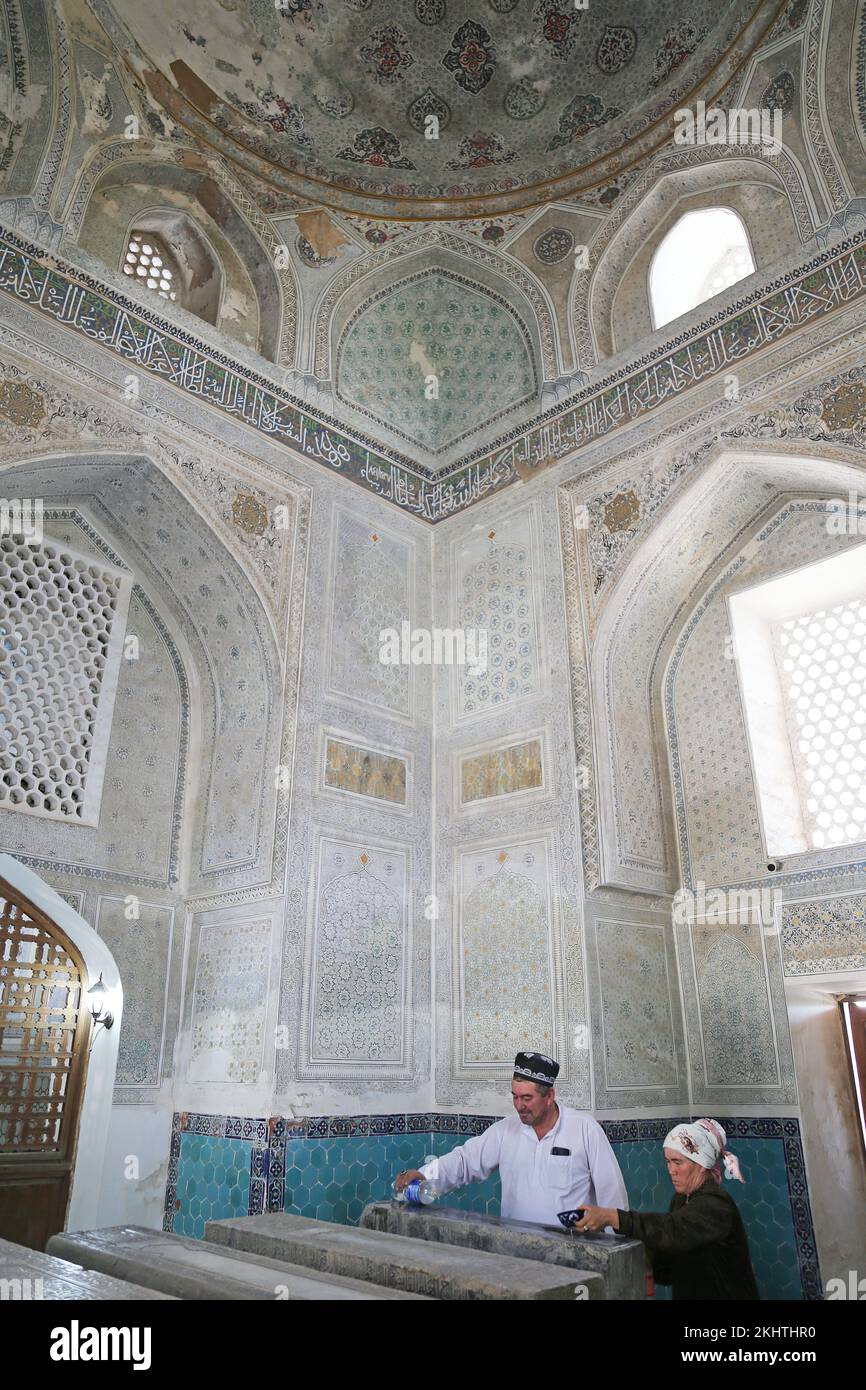 Imam benedice l'acqua per curare un bambino malato, Mausoleo di Gumbazi Saidon, complesso di AK Saray, Shakhrisabz, Provincia di Qashqadaryo, Uzbekistan, Asia centrale Foto Stock