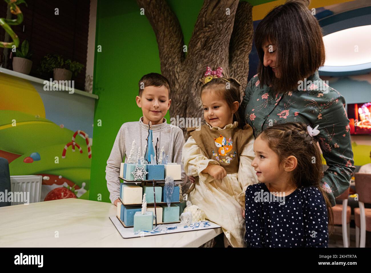 Ternopil, Ucraina - 17 novembre 2022: Madre con tre bambini e torta congelata in festa di compleanno bambino. Foto Stock