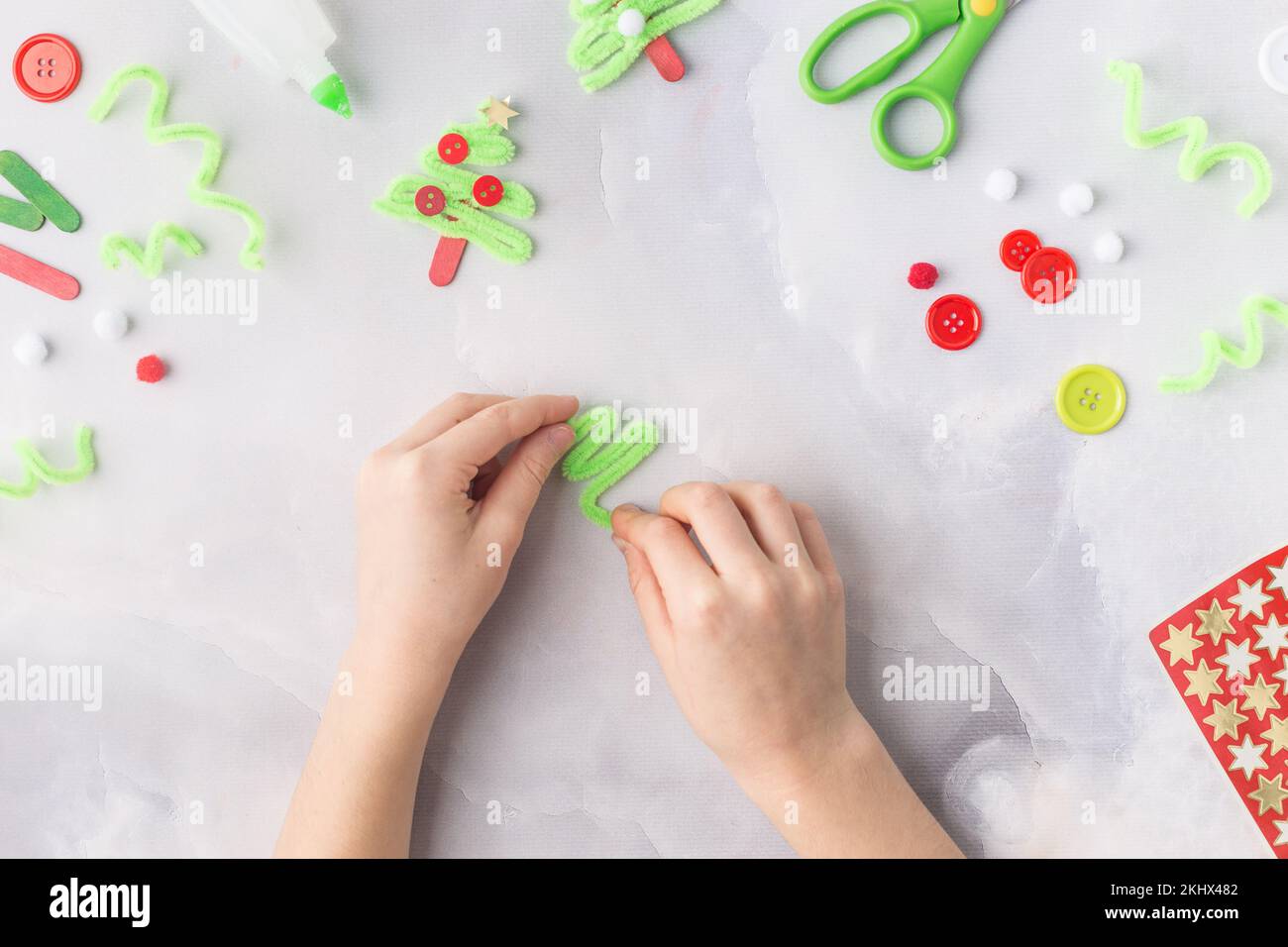 Il bambino fa un collage di carta di Natale di biglietto d'auguri. Realizzato con le proprie mani. Progetto artistico per bambini. Artigianato per bambini. Vista dall'alto Foto Stock