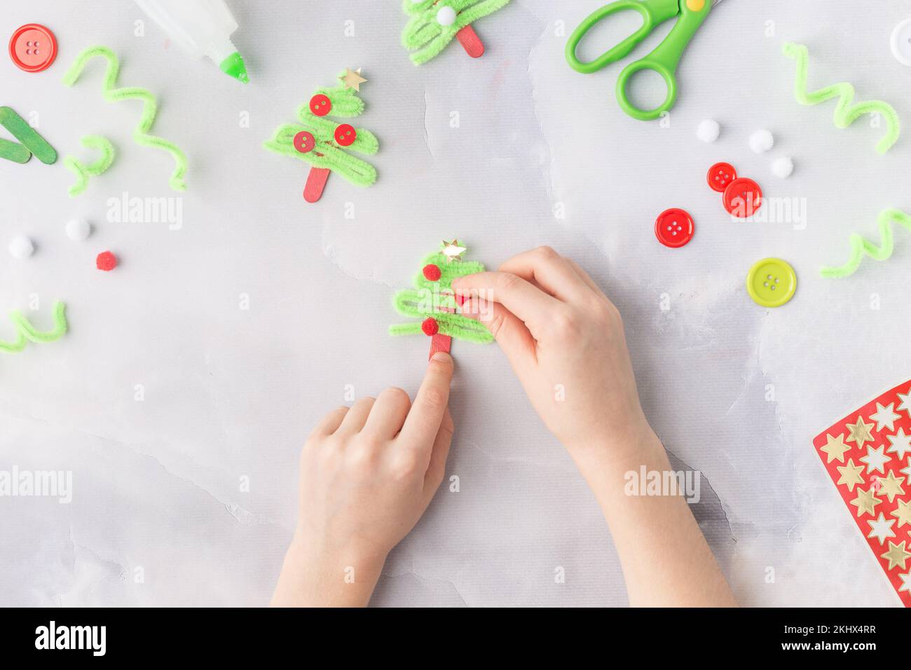 Il bambino fa un collage di carta di Natale di biglietto d'auguri. Realizzato con le proprie mani. Progetto artistico per bambini. Artigianato per bambini. Vista dall'alto Foto Stock