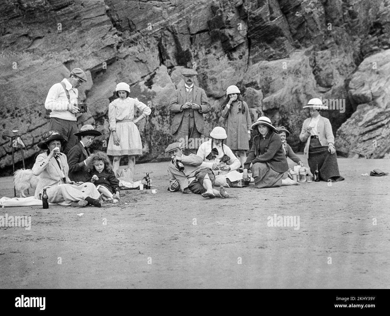Una fotografia in bianco e nero dei primi anni del 20th° secolo che mostra una famiglia che ha un picnic su una spiaggia a Criccieth, sulla costa occidentale del Galles. Foto Stock