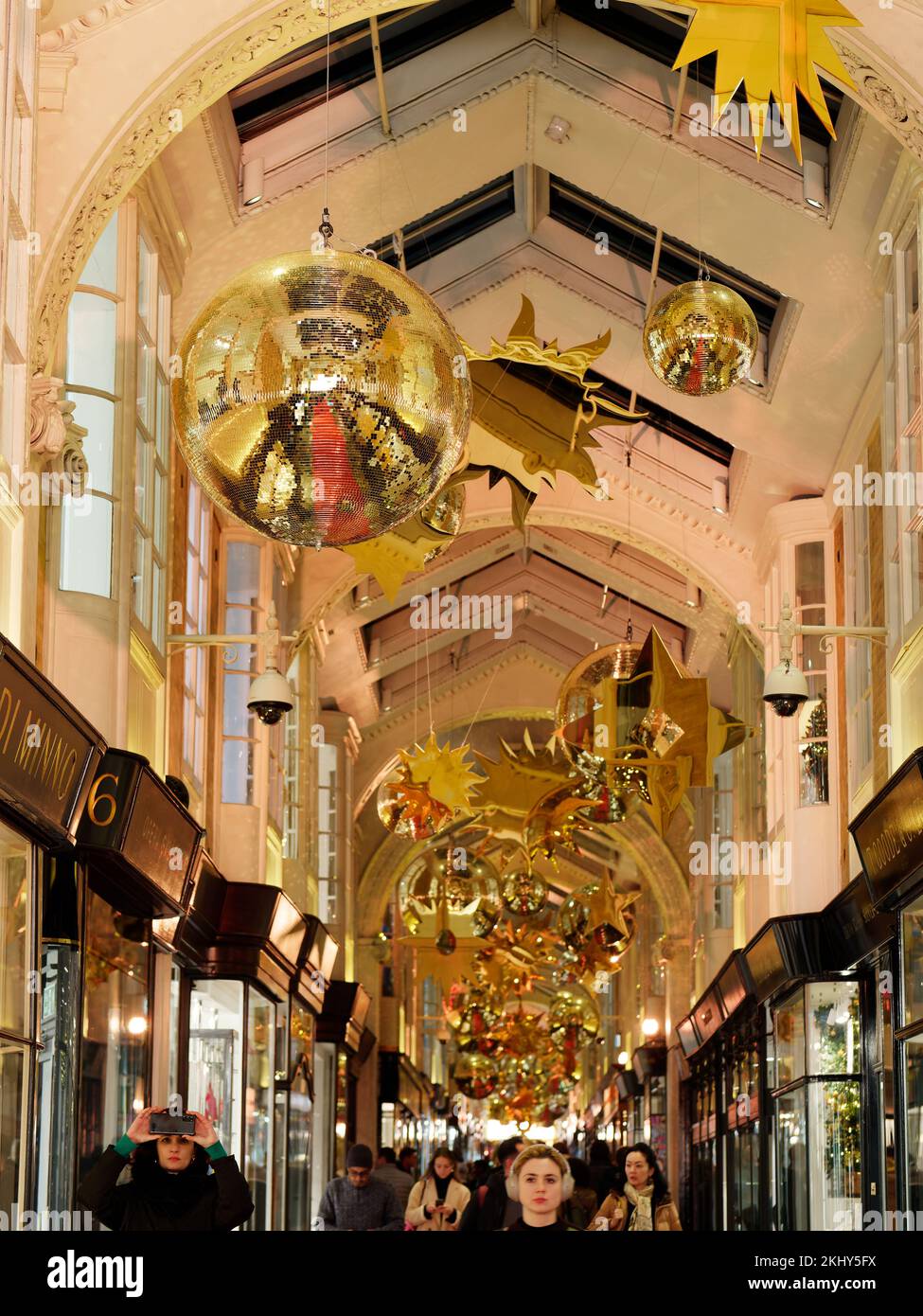 Burlington Arcade con decorazioni natalizie, un iconico centro commerciale di lusso a Piccadilly, Londra. Acquirenti con una donna che scatta una foto. Foto Stock
