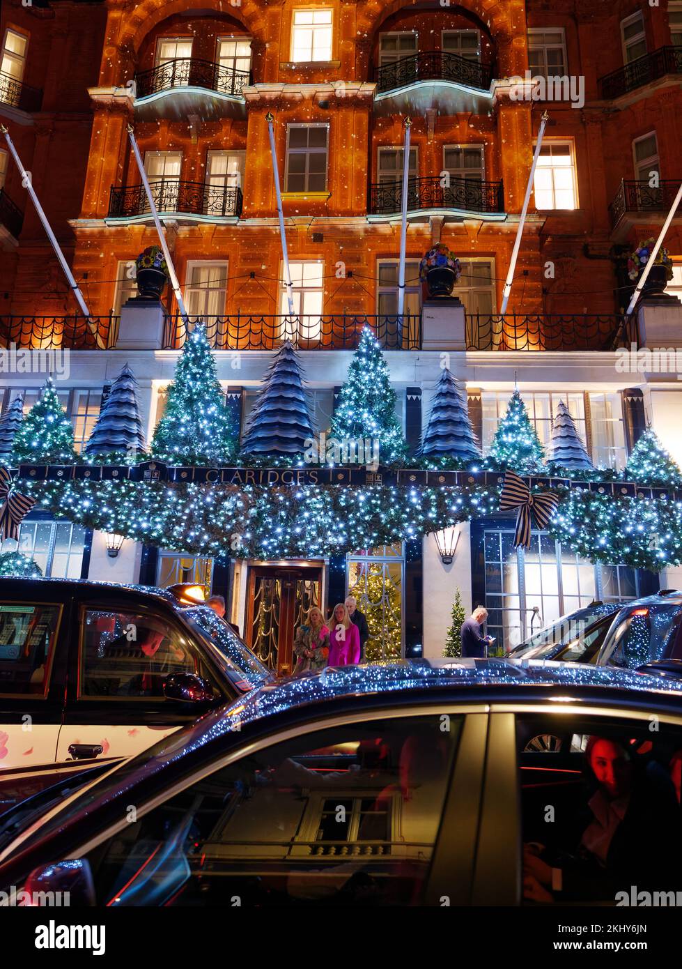 L'iconico hotel Claridge mostra la facciata di Natale. I taxi aspettano fuori dall'albergo mentre le decorazioni si riflettono sul parabrezza. Foto Stock