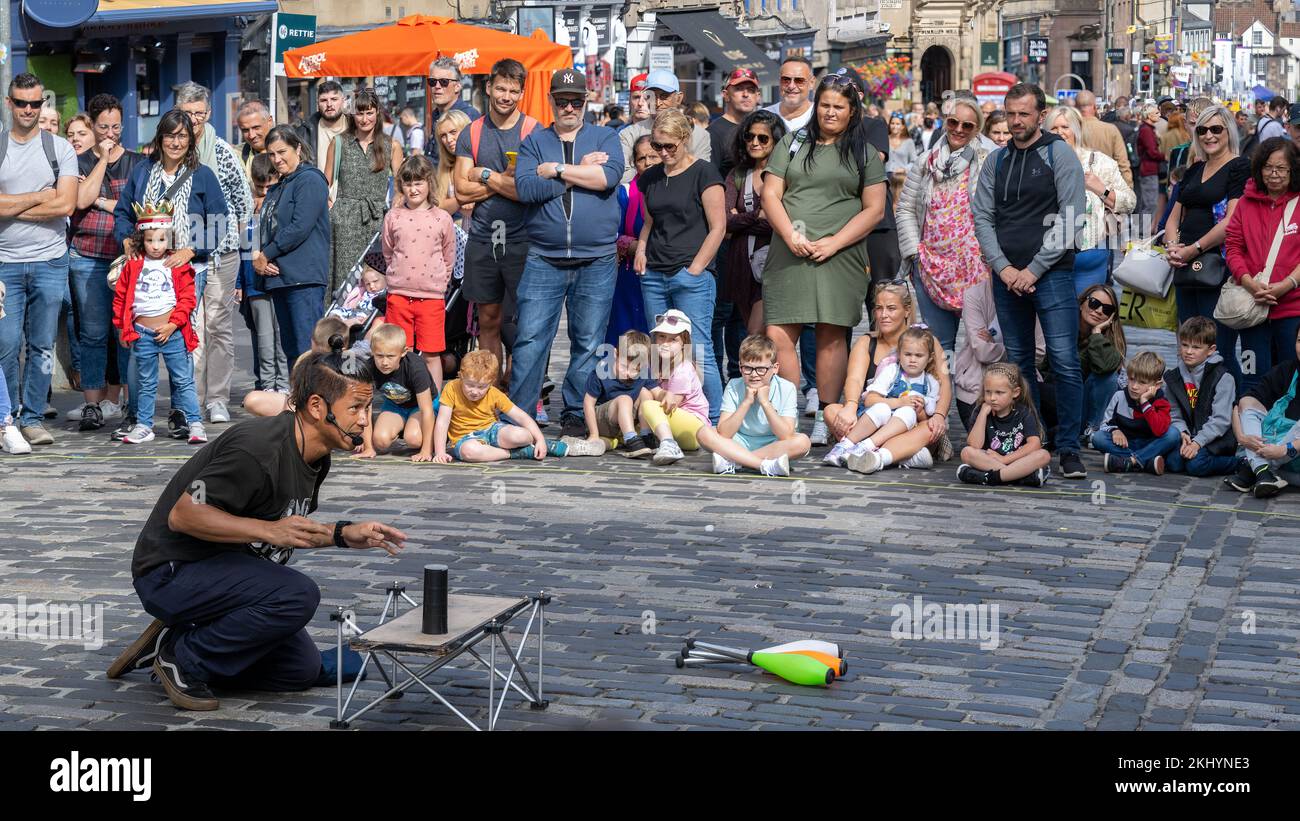 Uno spettacolo di Edinburgh Fringe Street intrattiene un pubblico di adulti e bambini sul Royal Mile di Edimburgo con un mix di magia e giocoleria. Foto Stock