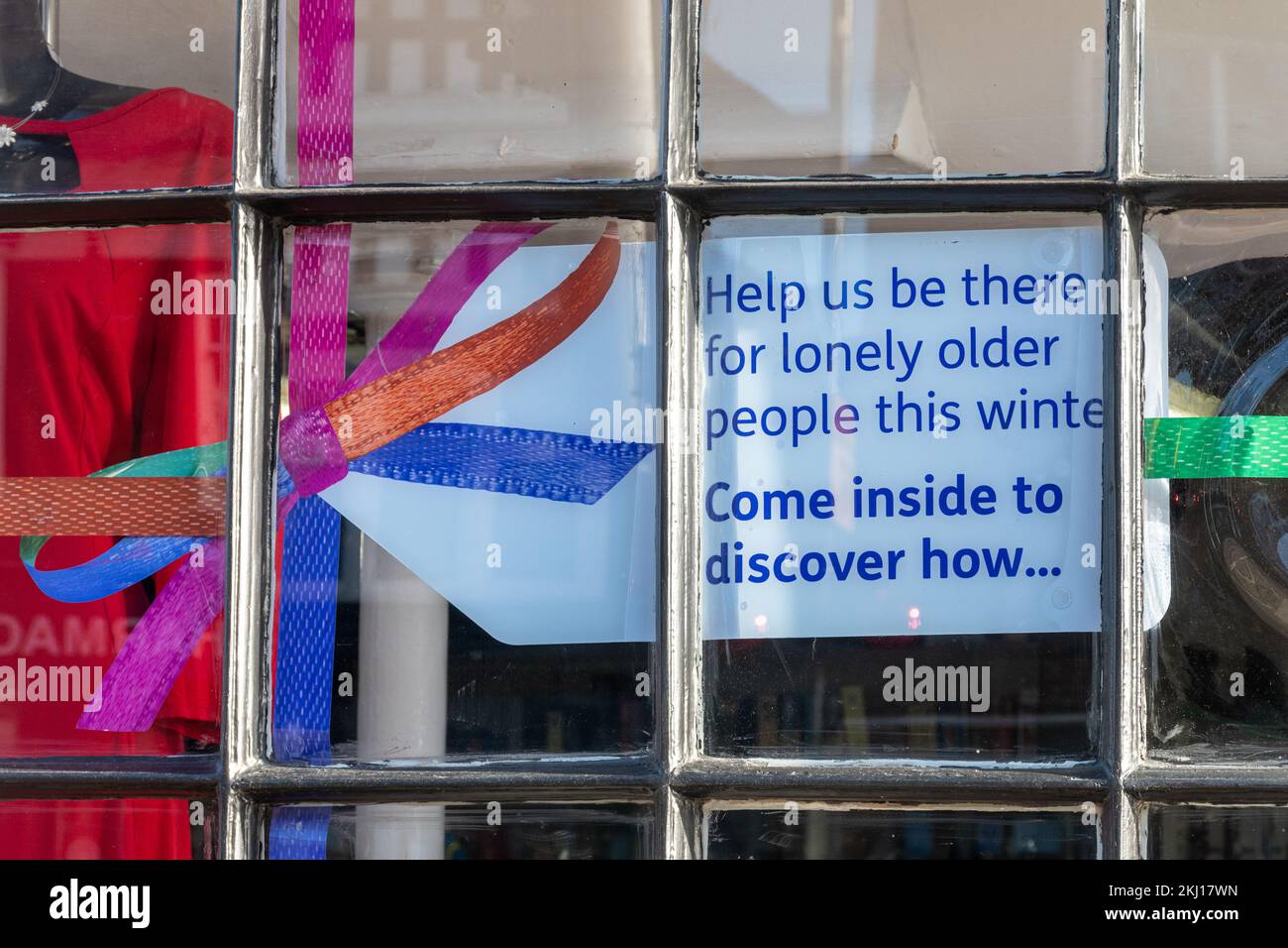 Sign in Age UK Charity Shop 'Aiutaci a essere lì per le persone solitarie più anziane questo inverno. Vieni a scoprire come...', Inghilterra, Regno Unito, novembre 2022 Foto Stock