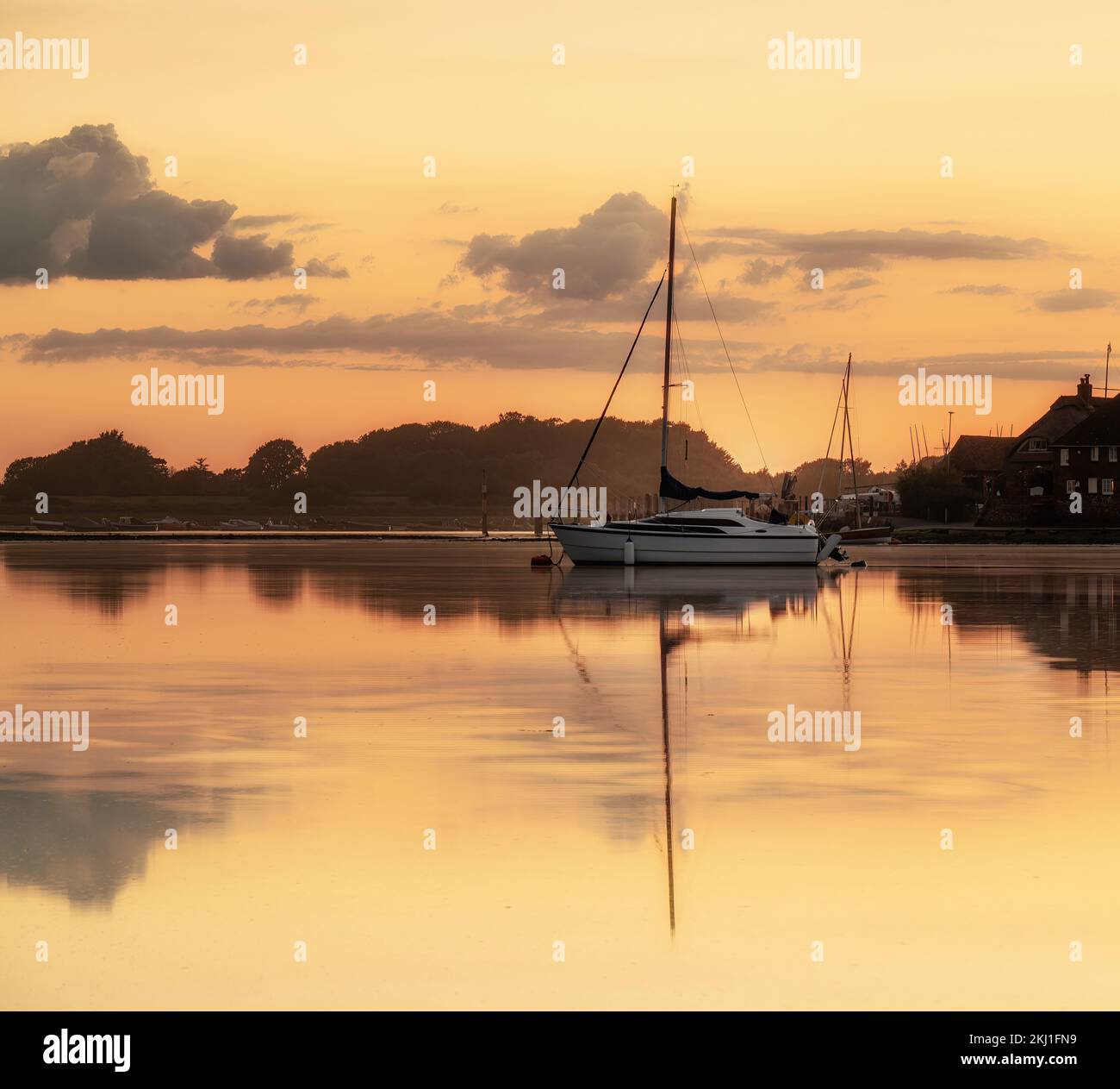 Una foto serale della banchina di Bosham con barca sull'acqua calma. Foto Stock