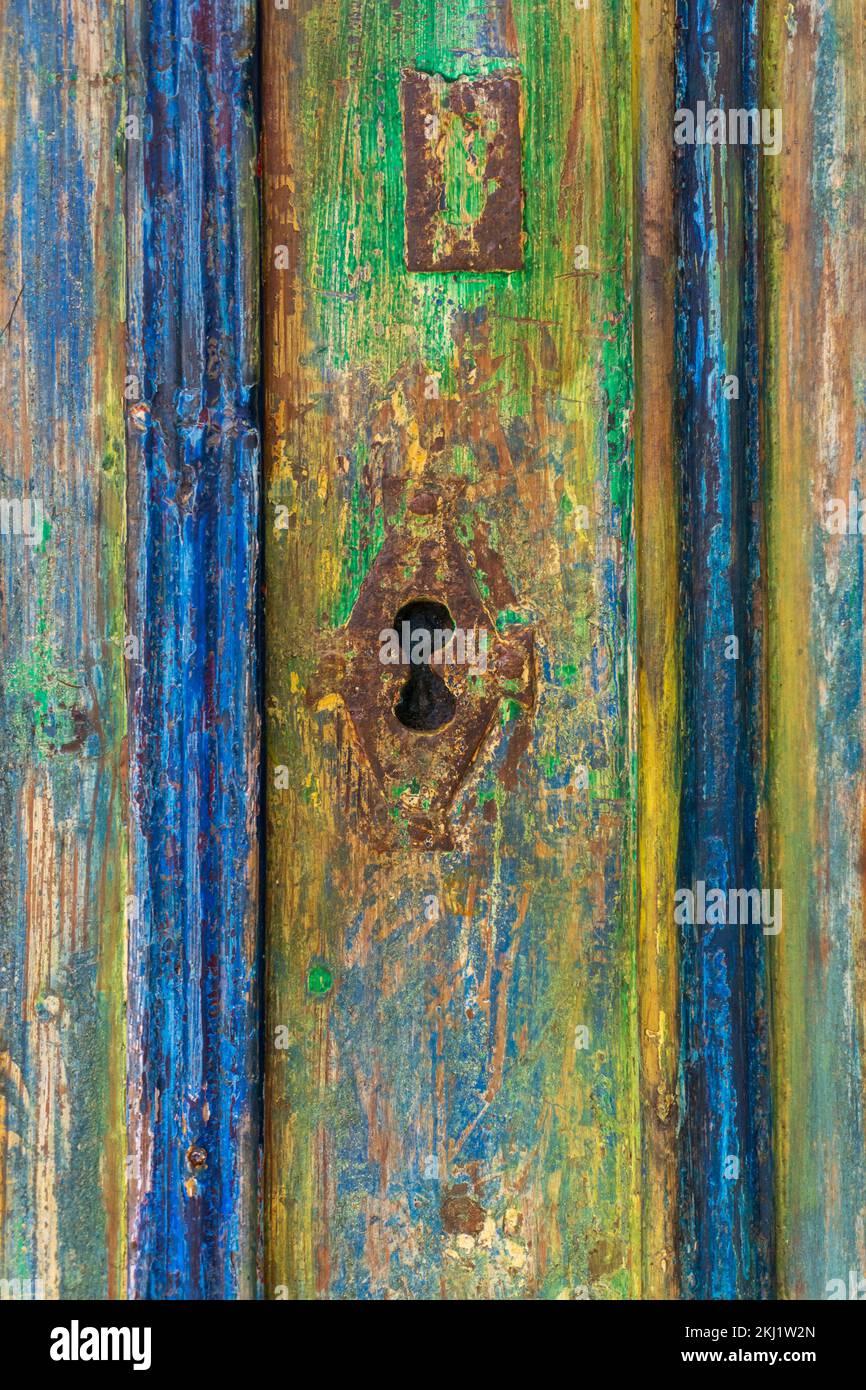 Toppa su una vecchia porta coperta da molti strati di vernice colorata Foto Stock