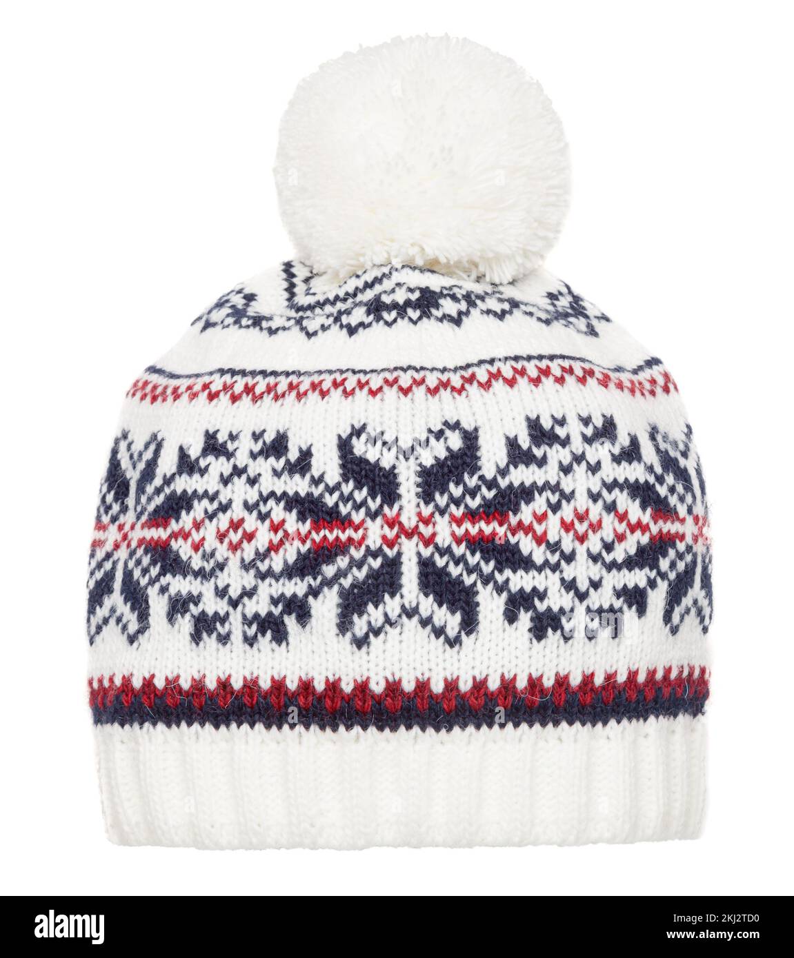 Cappellino invernale lavorato a maglia bianca decorato con ornamenti geometrici scandinavi. Cappuccio in lana fatto a mano con pompon sopra Foto Stock