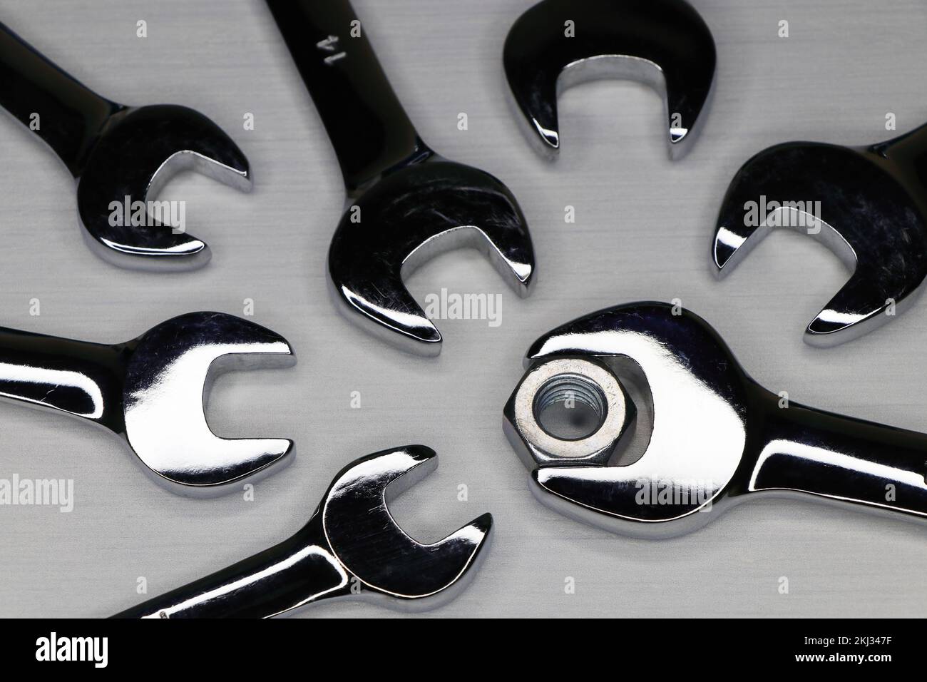 Chiavi con dado esagonale in acciaio su superficie bianca Foto Stock