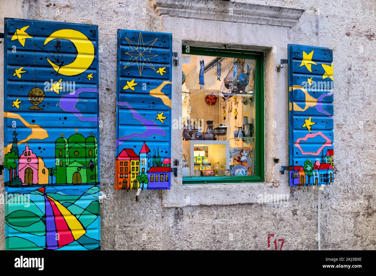 Finestre con persiane colorate decorate in modo luminoso su un negozio nella città vecchia di Cattaro, Montenegro Foto Stock