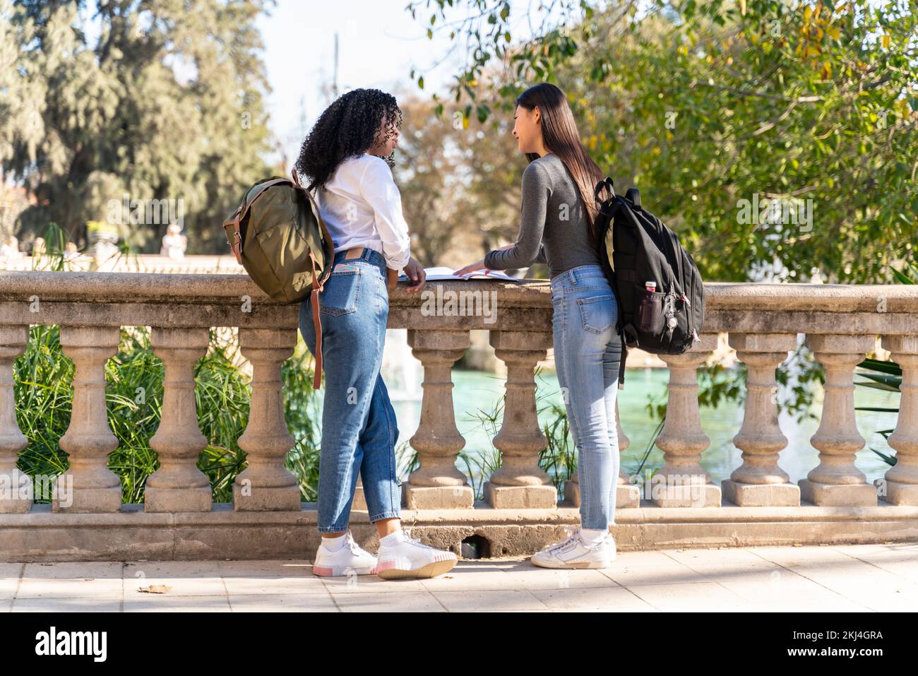 Due giovani studentesse per strada che guardano i loro quaderni Foto Stock