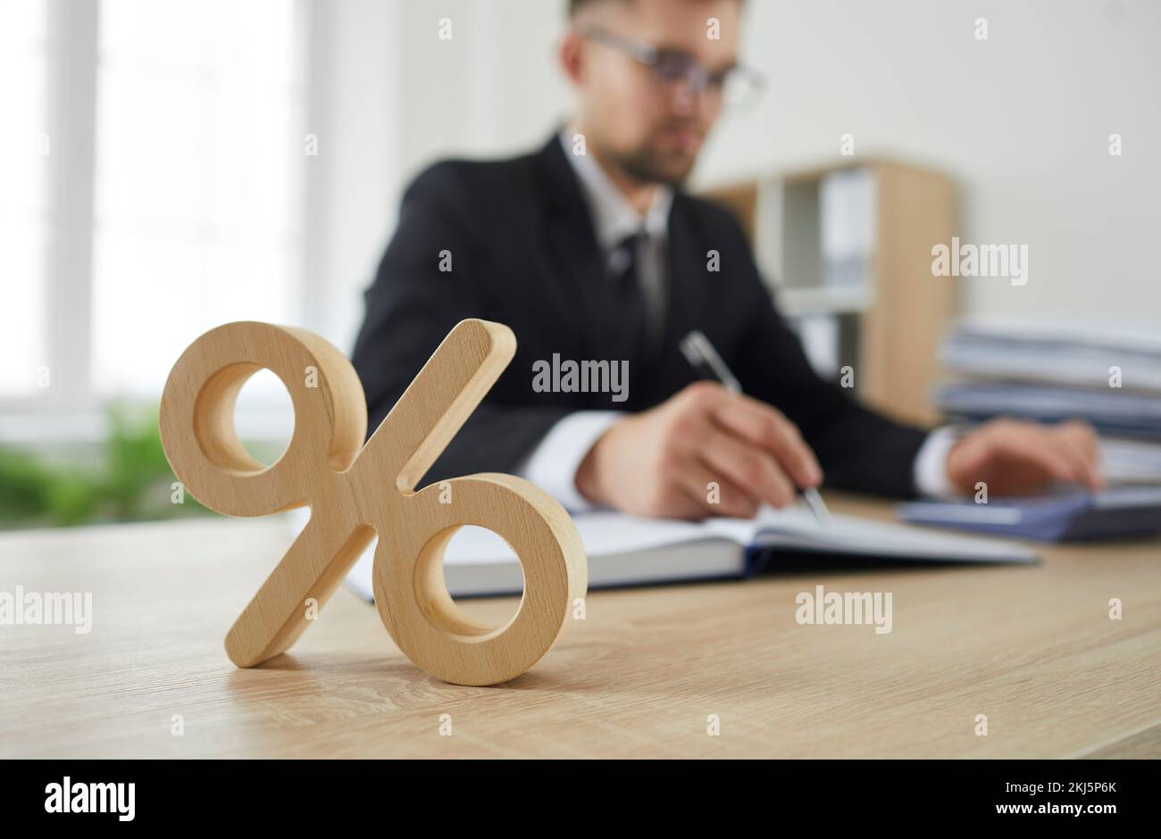 Primo piano di segno di legno percentuale sul tavolo come simbolo di imposta societaria e tasso di interesse. Foto Stock