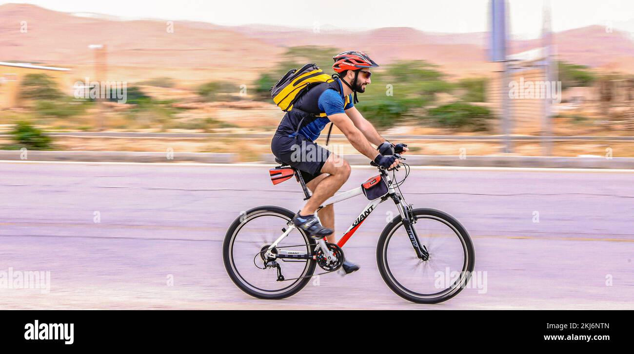 Un uomo che guida una bicicletta Foto Stock