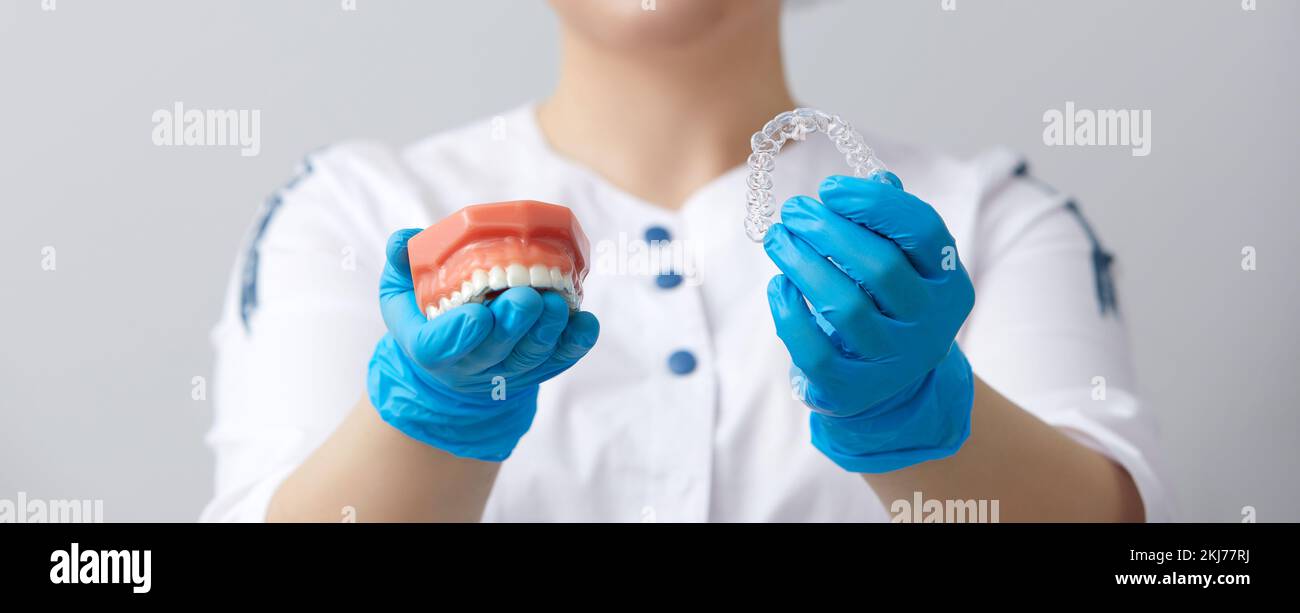 Ortodontista che mostra il sistema di allineatori su mascelle artificiali Foto Stock