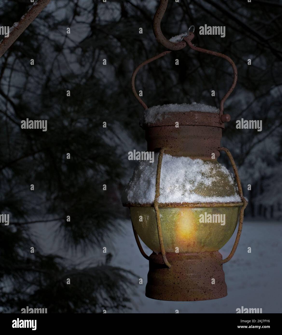 Vecchia lanterna coperta di neve appesa vicino ad un albero la vigilia di Natale Foto Stock