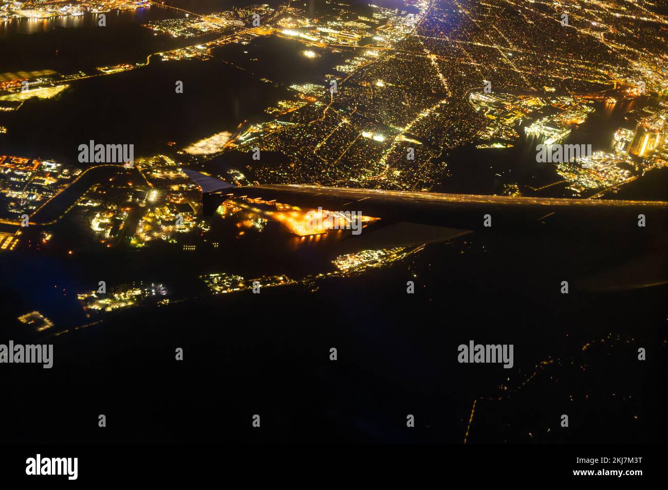 Vista dall'alto della città di notte, illuminata da luci luminose dalla finestra di un aereo che vola in alto nel cielo. Bellissimo paesaggio. Mappa, topografo Foto Stock