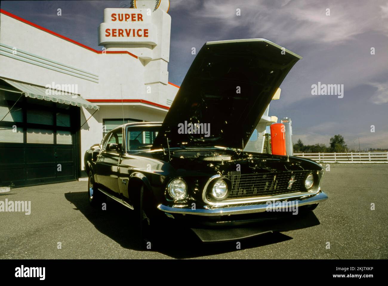 Fotografia vintage di una Ford Mustang Fastback del 1969 presso una stazione di servizio Texaco Foto Stock