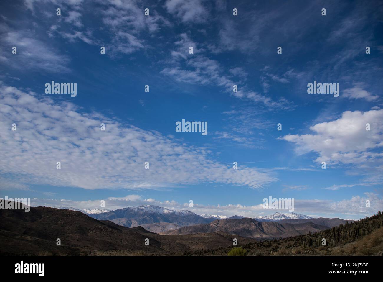 Terre asciutte e montagne innevate in fondo, in una vallata vicino al Monte Patria, nel nord del Cile Foto Stock