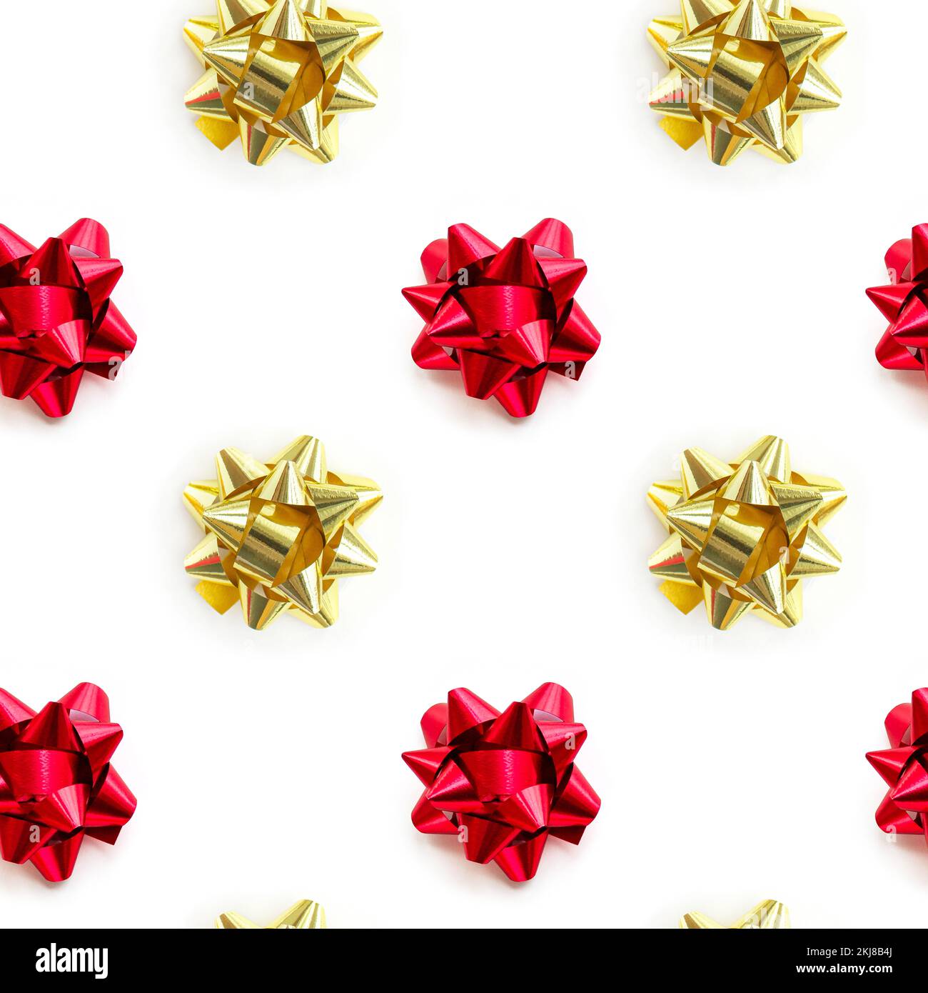 Oro natalizio e motivo a fiocco rosso su sfondo bianco. Composizione di disegno per carta da imballaggio, compleanno, natale o biglietto di auguri. Foto Stock