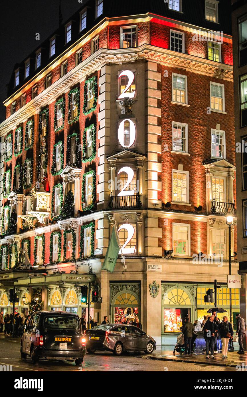 Londra, Regno Unito. 24th Nov 2022. La maggior parte dei grandi magazzini Fortnum & Mason è decorata per sembrare un gigantesco calendario dell'avvento, con l'anno, 2022, presentato all'angolo. La gente di Bond Street, la famosa strada dello shopping di Mayfair, e lungo Piccadilly curiosano tra le vetrine dei negozi e ammirano le numerose mostre colorate e le elaborate decorazioni a tema natalizio nei negozi di lusso di Mayfair. Credit: Imageplotter/Alamy Live News Foto Stock
