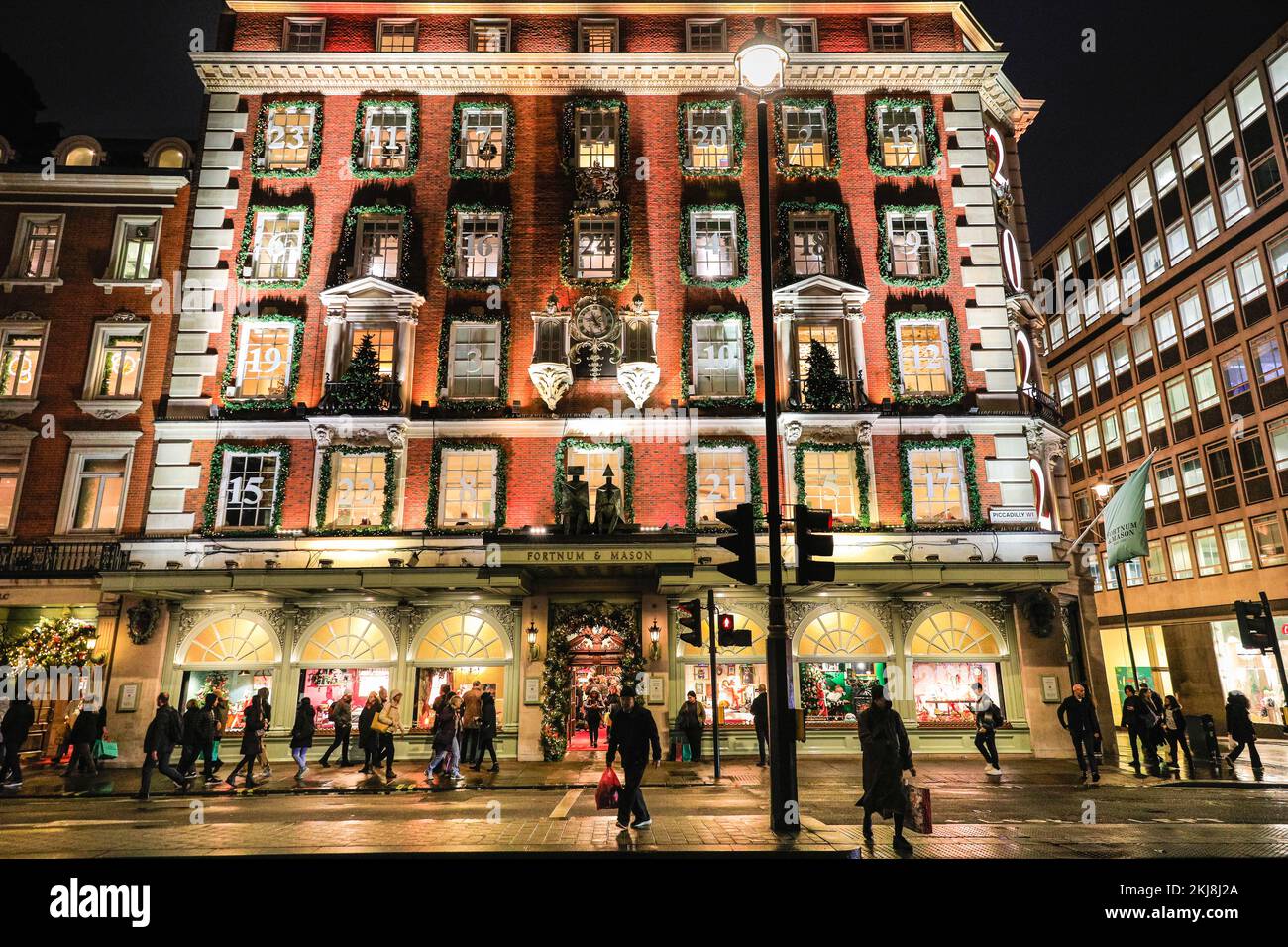 Londra, Regno Unito. 24th Nov 2022. La maggior parte dei grandi magazzini Fortnum & Mason è decorata per sembrare un gigantesco calendario dell'avvento, con l'anno, 2022, presentato all'angolo. La gente di Bond Street, la famosa strada dello shopping di Mayfair, e lungo Piccadilly curiosano tra le vetrine dei negozi e ammirano le numerose mostre colorate e le elaborate decorazioni a tema natalizio nei negozi di lusso di Mayfair. Credit: Imageplotter/Alamy Live News Foto Stock