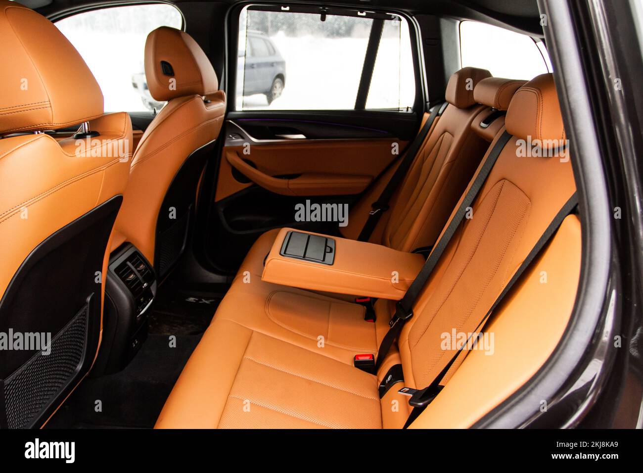 Moderna auto SUV all'interno. Sedili passeggeri posteriori in pelle nera in un'auto di lusso moderna con bracciolo aperto. Comodi sedili in pelle. Foto Stock
