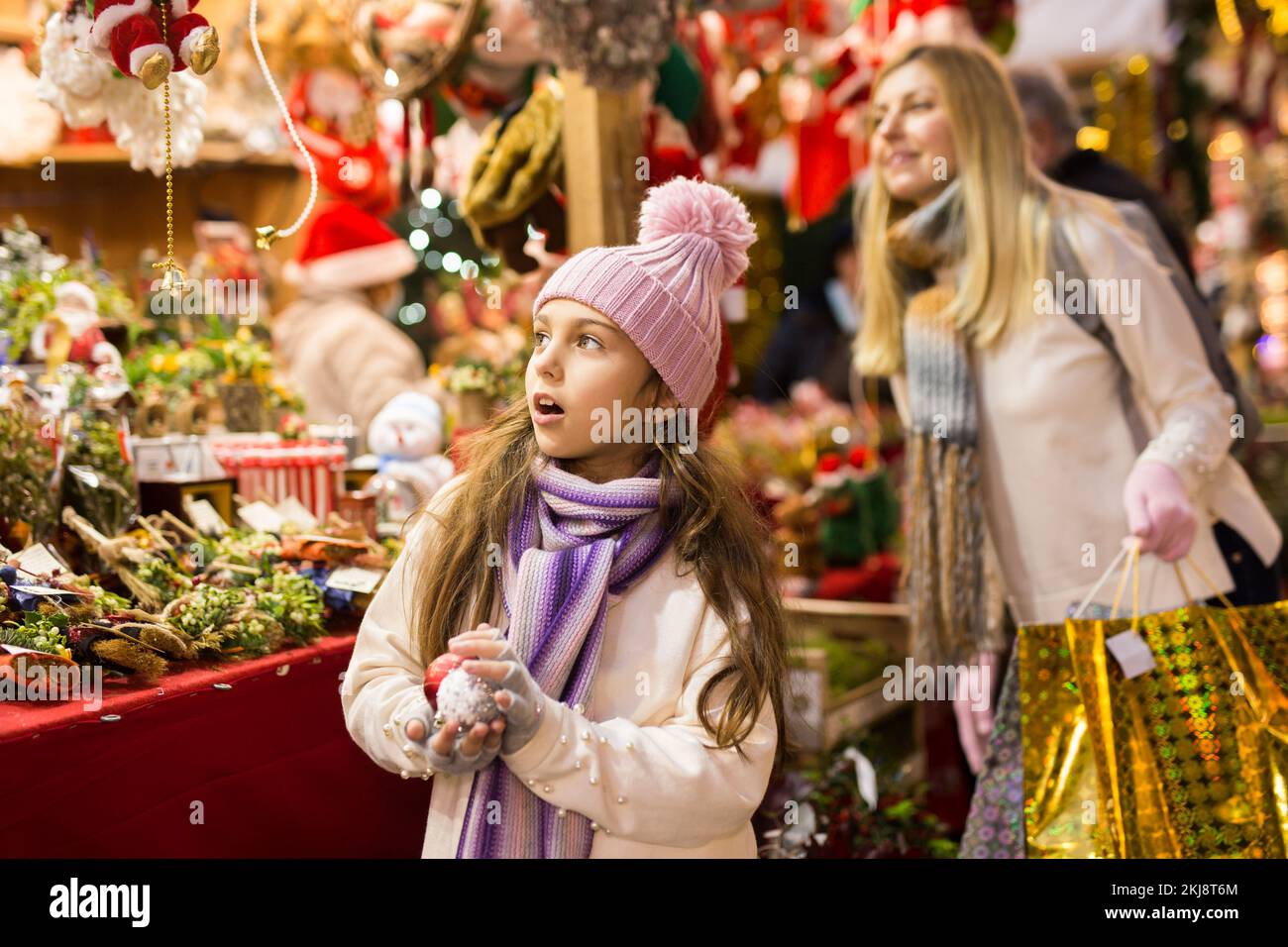 Ragazza entusiasta adolescente che sceglie le decorazioni dell'albero al mercato di strada Foto Stock