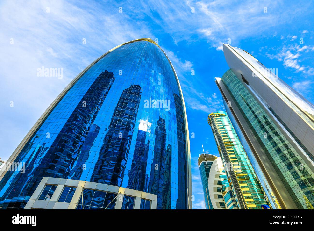 Doha, Qatar - 17 febbraio 2019: Woqod Tower con la sua forma futuristica e la facciata riflettente smaltata nella zona di West Bay. Grattacieli moderni a Doha Foto Stock