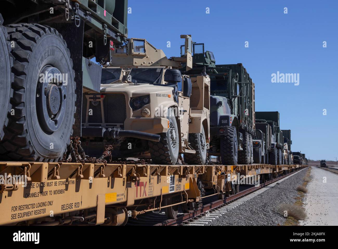 STATI UNITI I veicoli del corpo Marino sono incatenati giù su un automobile del treno durante le operazioni ferroviarie fra le armi e l'istruttore tattico (WTI) corso 1-23 vicino a Glamis, California, 4 novembre 2022. La stazione aerea del corpo marino Yuma, Arizona, ufficio di gestione della distribuzione ha assistito 1st battaglione di supporto dell'atterraggio, 1st gruppo di logistica della marina e 2nd battaglione di trasporto, 2nd gruppo di logistica della marina, mentre hanno caricato l'apparecchiatura che è estratta da WTI sulle automobili del treno, dal 31 ottobre al 7 novembre 2022. (STATI UNITI Corpo marino foto di Lance CPL. Jon C. Stone) Foto Stock