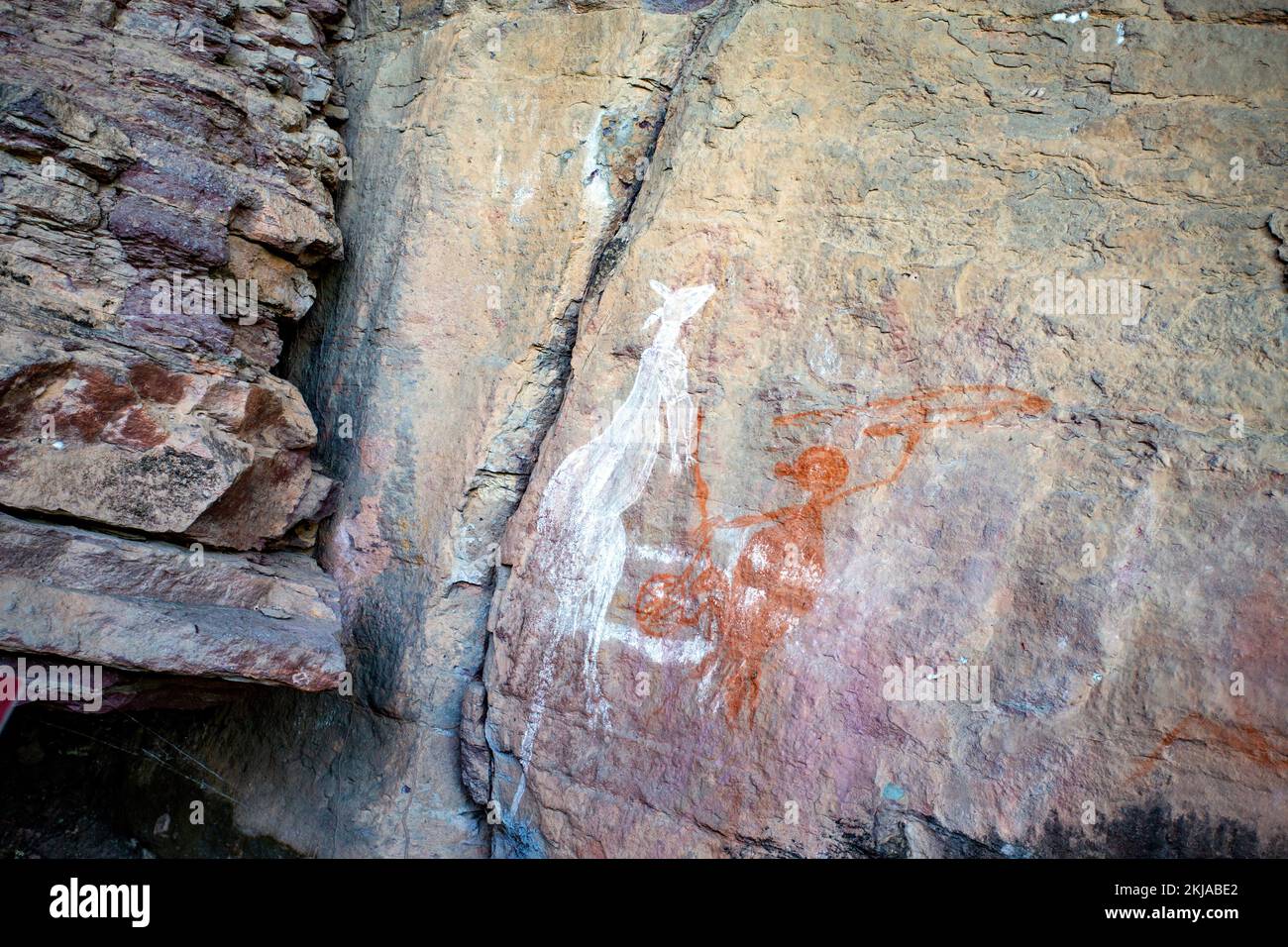 Vista panoramica del cacciatore in procinto di colpire il canguro con una lancia, presso il sito d'arte di Anbangbang nel Nourlangie Rock Site, Kakadu, territorio del Nord Foto Stock