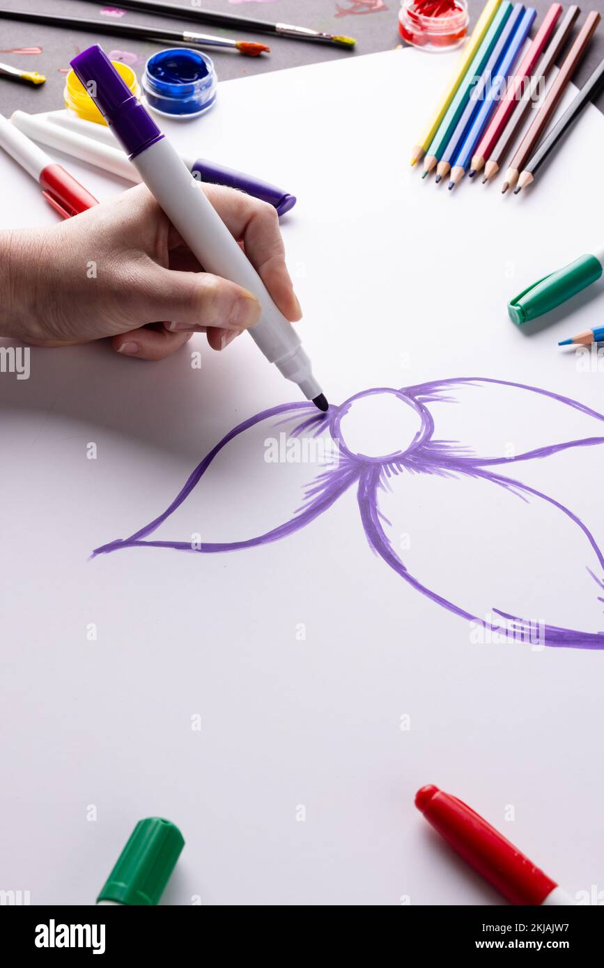 Immagine verticale del disegno a mano fiore viola su carta e materiali artistici sul piano del tavolo, spazio copia Foto Stock