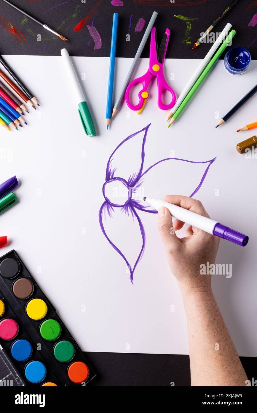 Immagine verticale del disegno a mano fiore viola su carta e materiali artistici sul piano del tavolo, spazio copia Foto Stock