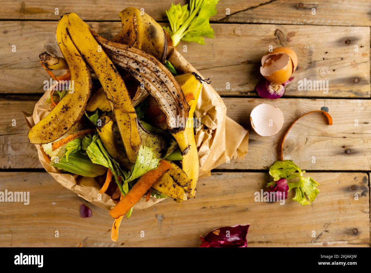 Overhead di frutta biologica e verdura cibo spreco versando da cucina completa compostaggio bidone Foto Stock