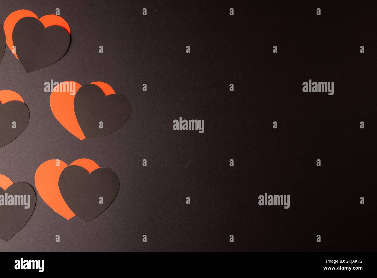 Forme di cuore rosse e nere su sfondo nero con spazio di copia Foto Stock