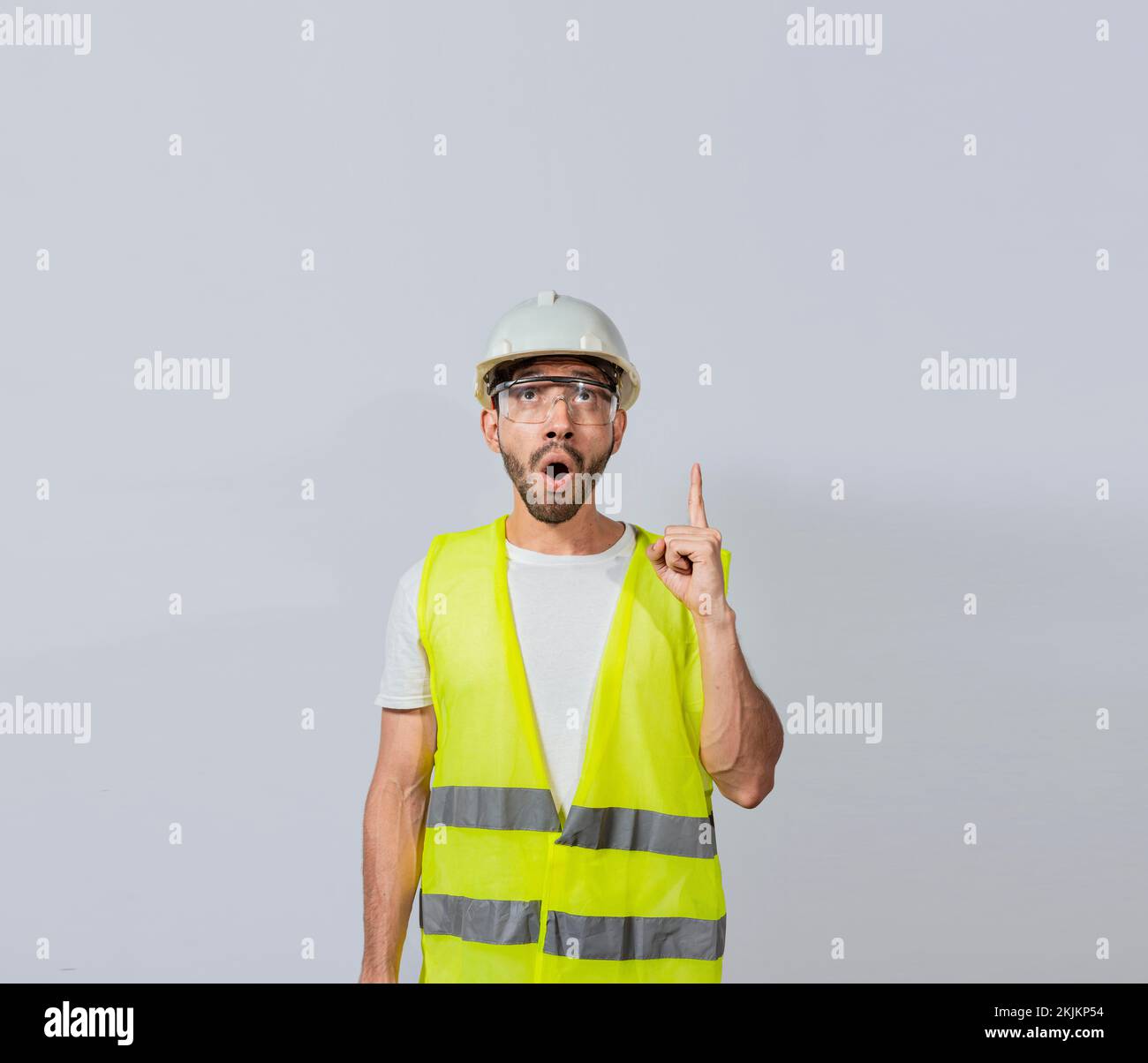 Un ingegnere stupito che indica, un giovane architetto sorpreso che indica, un ingegnere stupito che indica una pubblicità. Concetto di ingegnere con asto Foto Stock