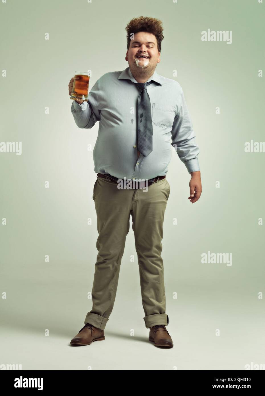 La birra è buona. un uomo sovrappeso che festeggia mentre tiene una pinta di birra. Foto Stock