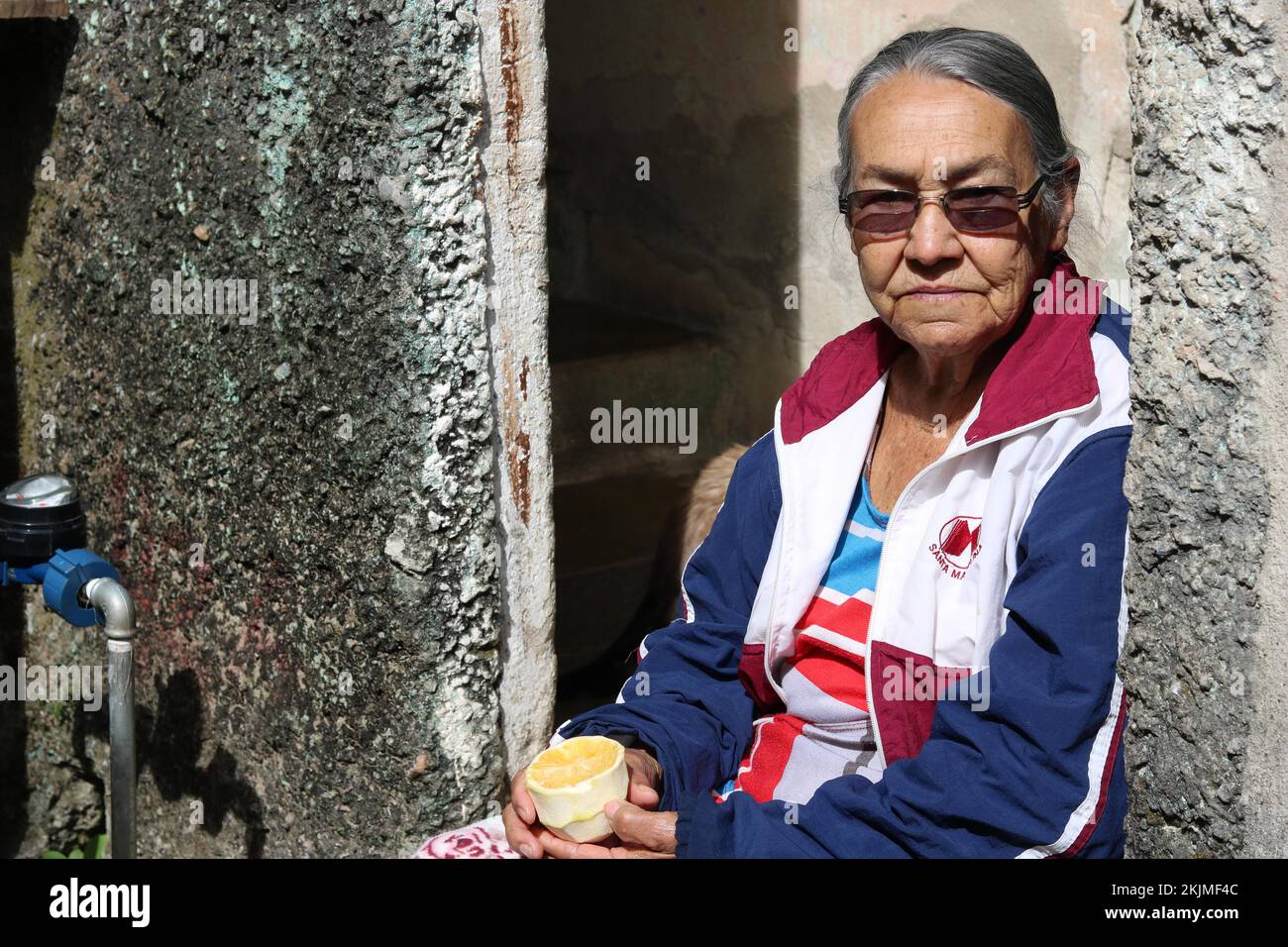 Favela, anziano che mangia un arancio alla porta della sua casa, Belo Horizonte, Minas Gerais, Brasile, Sud America Foto Stock