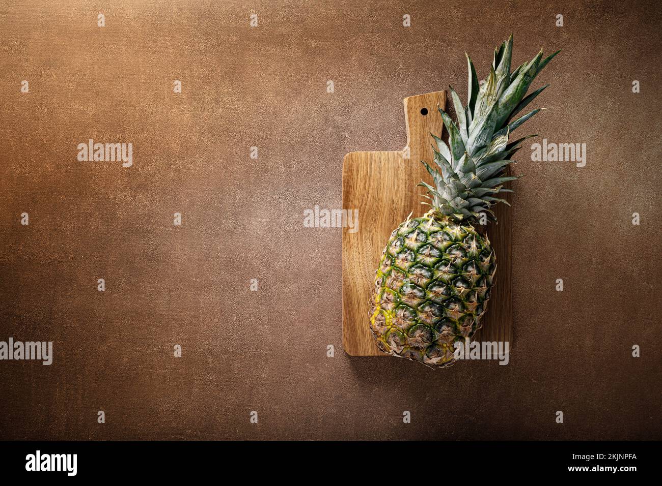 Ananas. Ananas intero su fondo marrone, masticare Foto Stock