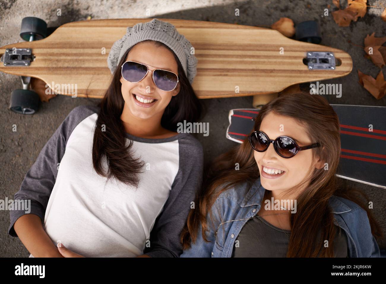 Fare una pausa. due giovani donne con i loro skateboard in città. Foto Stock