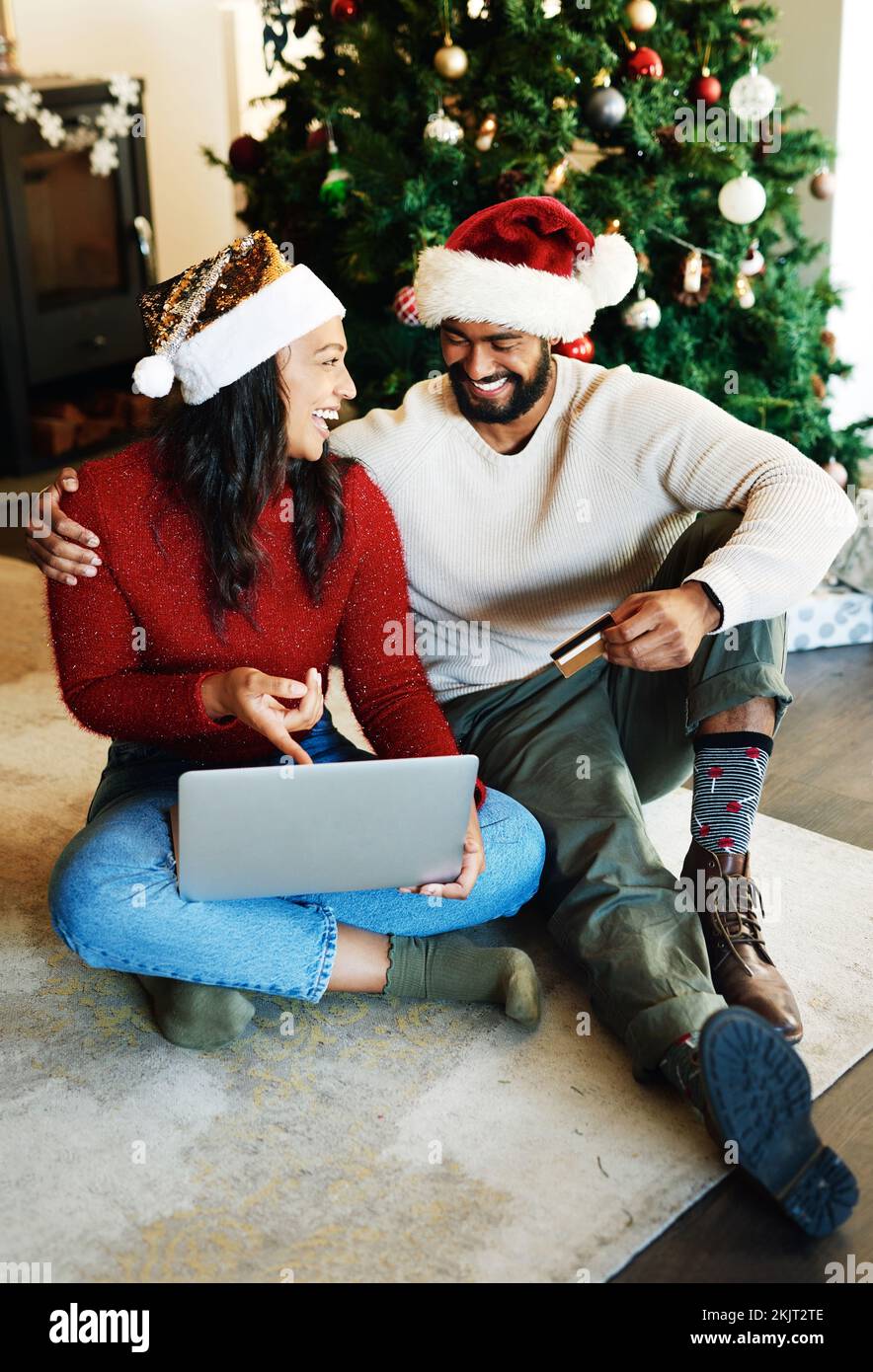 Natale, carta di credito e coppia shopping online, computer portatile e soggiorno, salotto e casa per regali, regali e vendite per le vacanze. Buon uomo, sorridere Foto Stock