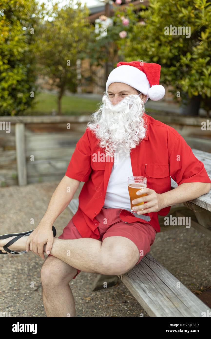 Un Babbo Natale a Natale in estate australiana con una birra Foto Stock