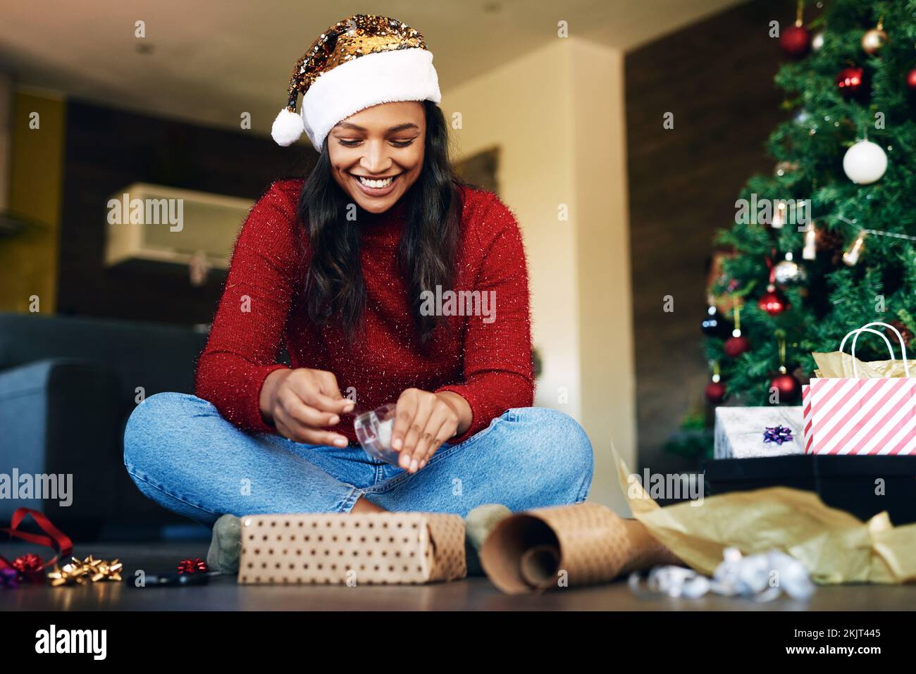 Donna, regalo di imballaggio per Natale con nastro e scatola regalo, festa di festa e felicità. Donna felice sul pavimento del soggiorno, presente con nastro Foto Stock